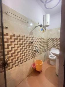 a bathroom with a toilet and a bucket at Hotel Aradhya Gange Residency Tapovan Rishikesh - Excellent Service Awarded in Narendranagar