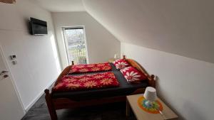 Schlafzimmer mit einem Bett mit roter Bettwäsche und einem Fenster in der Unterkunft Ferienhaus in Walow in Walow
