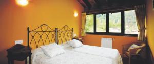 een slaapkamer met een wit bed en een raam bij El Crucial in Cangas de Onís