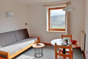 a small living room with a couch and a table at Gîte Les 4 Saisons in Orbey