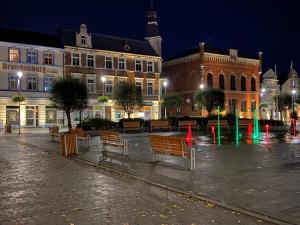 a city square with benches and buildings at night at Pucka Marina in Puck