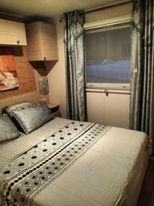 a bedroom with a bed and a large window at Village l oasis in Puget-sur-Argens