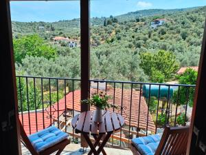 a balcony with a table and chairs and a view at AMMOS & ASTERIAS FAMILY APARTMENTS in Kálamos
