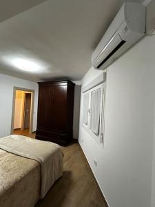 a bedroom with a bed and a brown cabinet at El Coso in Santa Cruz de la Zarza