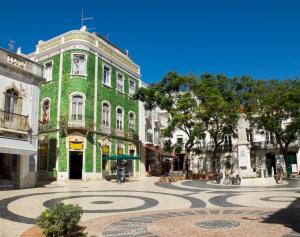 a green building with a spiral in the middle of a street at Praia da Luz Monique Apartment in Luz