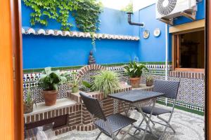 a patio with a table and chairs and a blue wall at Lola´s winery house, andalusian patio in Granada
