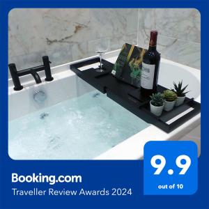 a bottle of wine on a tray in a bath tub at Luxury 1 Bedroom Duplex with Free Parking in Plymouth
