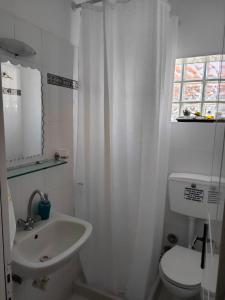 a white bathroom with a sink and a toilet at AMMOS & ASTERIAS FAMILY APARTMENTS in Kálamos