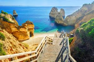 a staircase leading to a beach near the ocean at Praia da Luz Monique Apartment in Luz