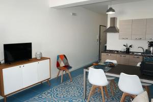 een woonkamer met een tv en een tafel en stoelen bij Orizzonte Blu apartment - Macari Bay in Macari
