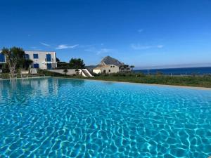 een grote plas blauw water met gebouwen op de achtergrond bij Orizzonte Blu apartment - Macari Bay in Macari