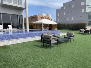 a patio with chairs and a table and a pool at Sama Chalet kuwait in Al Khīrān
