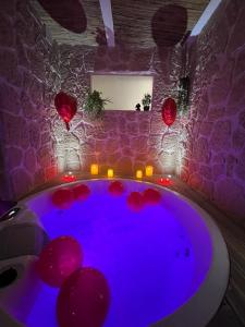 勒格羅－迪魯瓦的住宿－Les Spas de la mer, Suite & Spa, Love room, Plein Cœur du Grau，浴缸位于红灯的房间