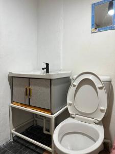 曼谷的住宿－Chubby 5 Room 5，浴室配有白色卫生间和盥洗盆。