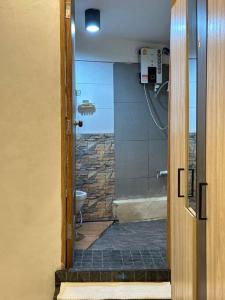 baño con ducha y aseo con puerta de cristal en Chubby 5 Room 5 en Bangkok