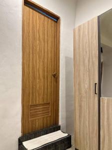 a wooden door in a room with a staircase at Chubby 5 Room 5 in Bangkok