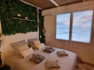 a bed with towels on it in a room with a window at Les Spas de la mer, Suite & Spa, Love room, Plein Cœur du Grau in Le Grau-du-Roi