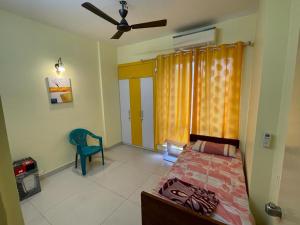 sypialnia z łóżkiem i wentylatorem sufitowym w obiekcie Merlin Legacy w mieście Kolkata