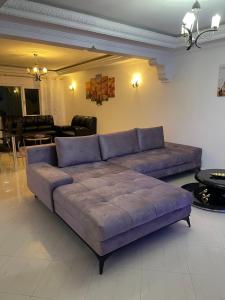 een grote paarse bank in de woonkamer bij Apartamento exclusivo in Tanger