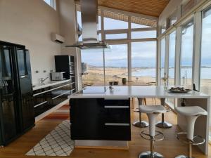 una cocina con una gran isla con taburetes en Geithellar, en Djúpivogur