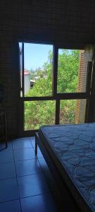 um quarto com três janelas e uma cama num quarto em Sobrado com vista profissional do mar em Arroio do Sal