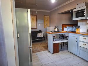 eine Küche mit blauen Schränken und einer Couch in einem Zimmer in der Unterkunft 1@Kruger in Mokopane