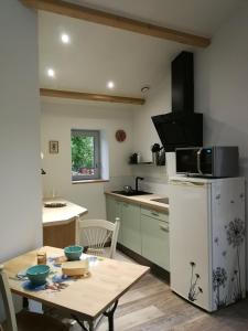een kleine keuken met een tafel en een magnetron bij Gite Coté Jardin 2pers. in Saint-Gelais