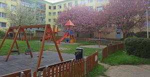 a playground in a park with two swings at Sunny & Spacious, 10mins to Centre, Free parking, Quiet location, New Furniture, Balcony in Prague