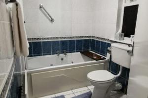 a bathroom with a toilet and a bath tub and a toilet at Bru Na Pairc B&B in Bantry