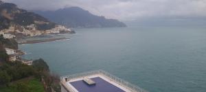uma vista para uma massa de água junto a uma montanha em Amalfi Blu Paradise em Amalfi