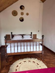 a bedroom with a bed and a rug on the floor at La Sirena Ambositra in Ambositra