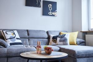a living room with a couch and a table with wine glasses at IDEE Living: Altstadt-Apartment im Herzen d. Pfalz in Neustadt an der Weinstraße