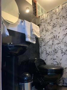 a bathroom with a black toilet and a sink at Céntrico y acogedor apartamento in Cajamarca