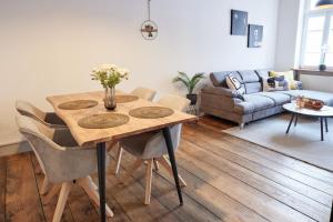 a living room with a wooden table and chairs at IDEE Living: Altstadt-Apartment im Herzen d. Pfalz in Neustadt an der Weinstraße
