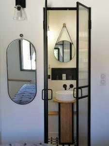 a bathroom with a sink and a mirror at La Petite Maison in Villeconin