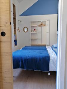 a bedroom with a bed with a blue blanket at La Petite Maison in Villeconin +7 photos