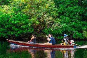 um grupo de pessoas em um barco na água em LUZ AMAZÔNIA LODGE em Iranduba