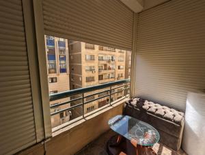 een balkon met een bank, een tafel en een raam bij Duplex by Aqua Maadi Degla Group 5 stars in Caïro