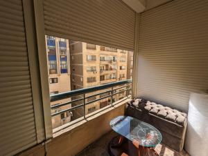 Duplex by Aqua Maadi Degla Group 5 stars في القاهرة: شرفة مع أريكة وطاولة ونافذة