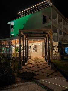 a building lit up at night with a green at Hotel Pedasí Nature Paradise in Pedasí Town