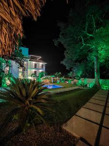 una casa con jardín por la noche con luces verdes en Hotel Pedasí Nature Paradise, en Pedasí Town