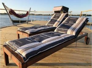 two beds sitting on a dock next to the water at Hausboot ELLA- Huus & Meer in Burgstaaken