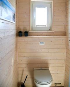 a small bathroom with a toilet and a window at Hausboot ELLA- Huus & Meer in Burgstaaken