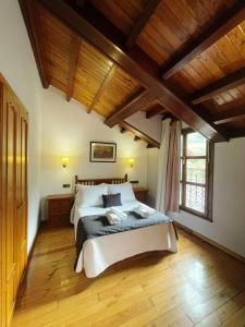 a bedroom with a large bed and wooden ceilings at Pensión Casa Morán in Benia de Onís