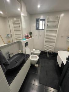 a bathroom with a black sink and a toilet at Apartament Central Tulcea in Tulcea