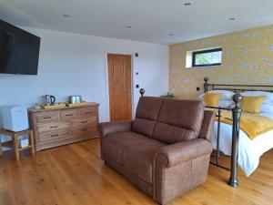 a bedroom with a bed and a couch and a chair at A Room with a View in Glastonbury