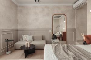 una camera con letto, divano e specchio di Luxury Suites by Lato ad Ágios Nikólaos