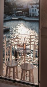 un tavolo e due sedie su un balcone con acqua di Luxury Suites by Lato ad Ágios Nikólaos