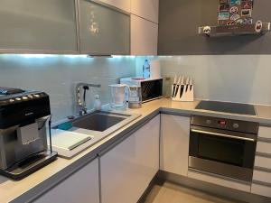 a kitchen with a sink and a microwave at Tacoma apartamenty in Warsaw