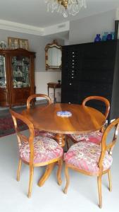 a wooden table with two chairs and a dining room at Appart. 3 chambres, jacuzzi en été, dans un jardin in Geneva